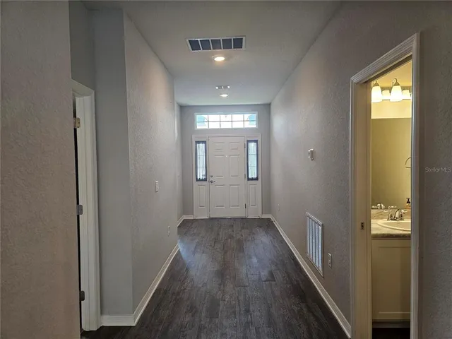 a view of a hallway with wooden floor