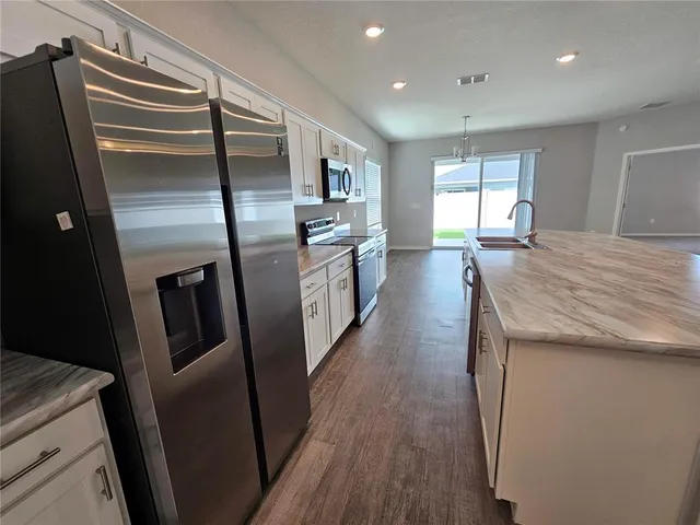 a kitchen with stainless steel appliances granite countertop a refrigerator and a stove