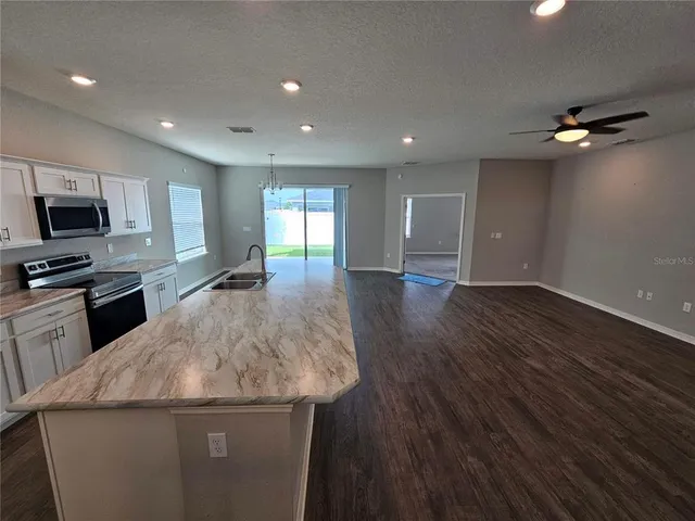 a kitchen with granite countertop sink stainless steel appliances and cabinets