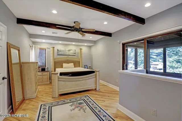 a view of a hallway with wooden floor and a living room