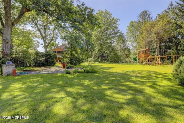 a view of swimming pool with yard and trees
