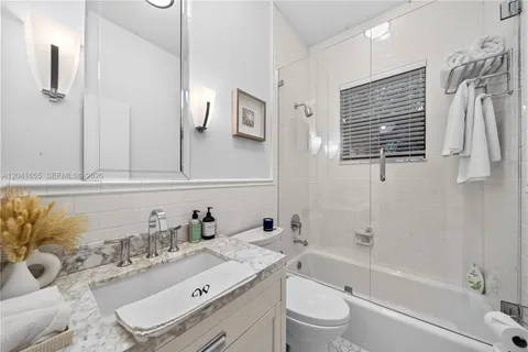 a bathroom with a sink toilet a mirror and shower