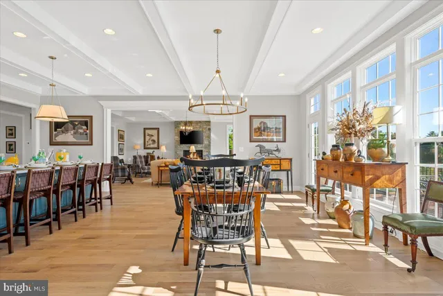 a view of a dining room and livingroom with furniture wooden floor a chandelier