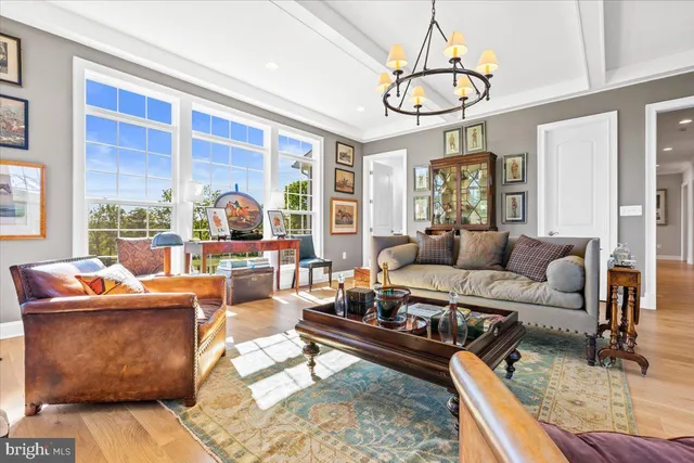 a living room with furniture a chandelier and a table