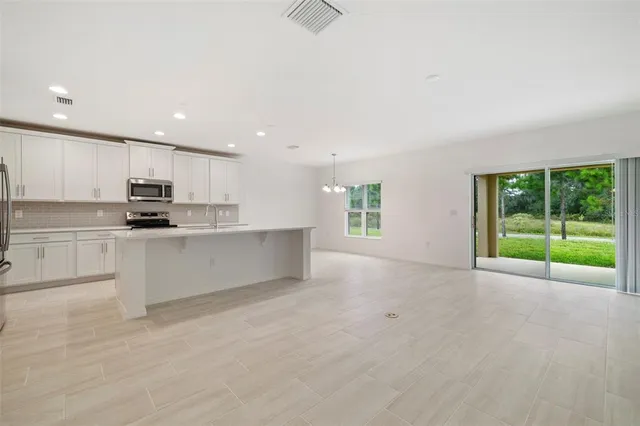 a view of kitchen with stainless steel appliances granite countertop a stove a sink and a microwave
