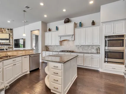a large kitchen with stainless steel appliances granite countertop a stove and a sink