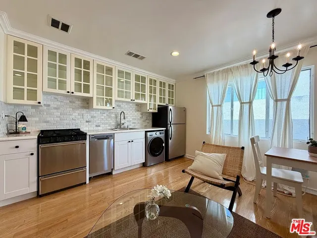 a kitchen with granite countertop a stove a sink and dishwasher wooden cabinets with wooden floor