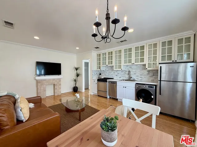 a kitchen with a table chairs stainless steel appliances and cabinets