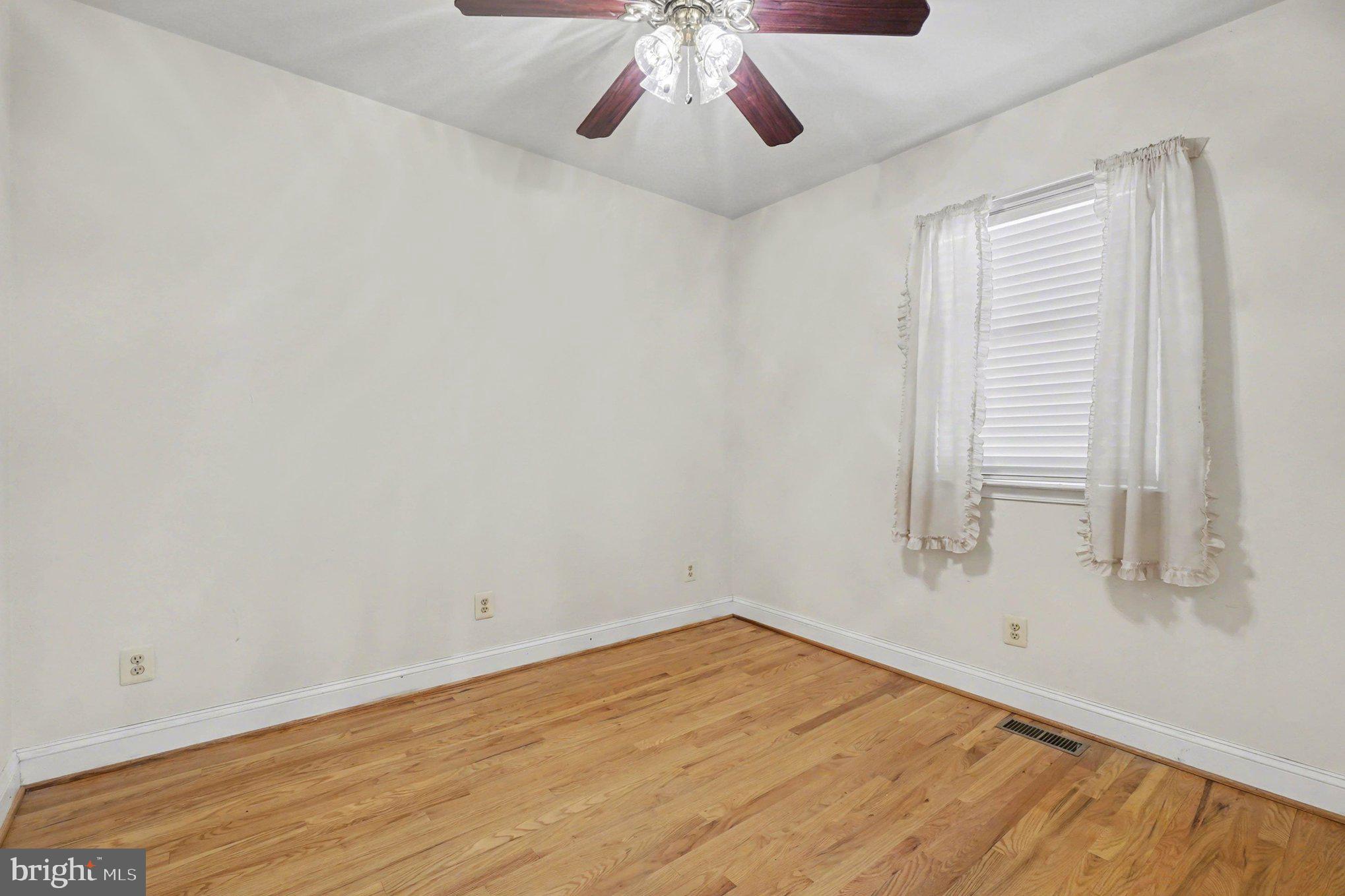 7908 Oakleigh Road Baltimore, MD 21234 - Photo 15 of 41 wooden floor in an empty room with a window