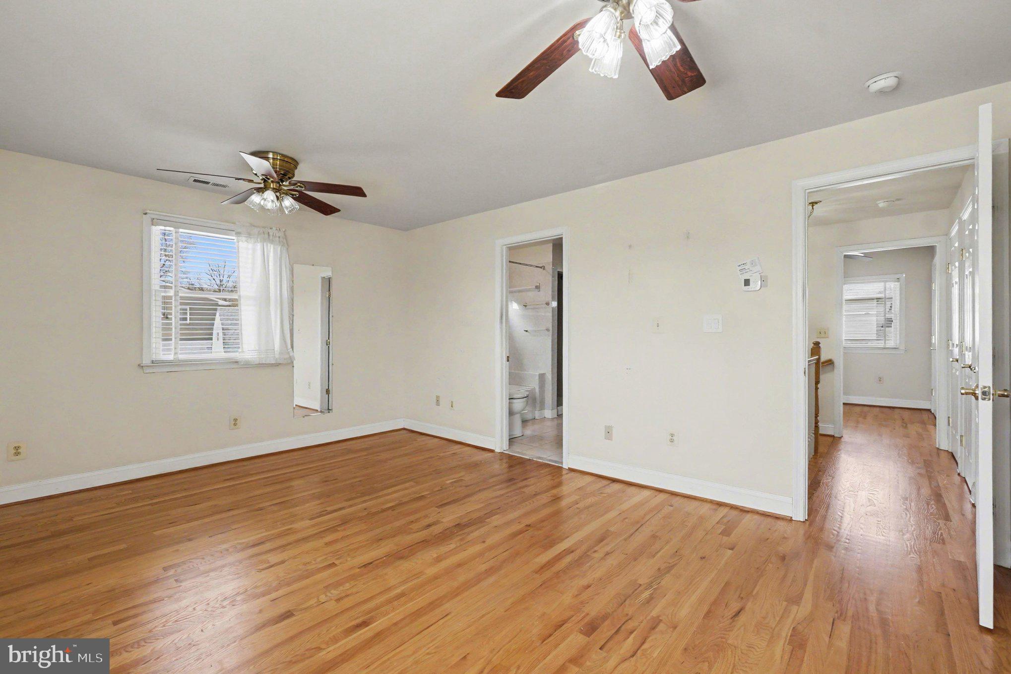 7908 Oakleigh Road Baltimore, MD 21234 - Photo 19 of 41 a view of an empty room with a window and wooden floor