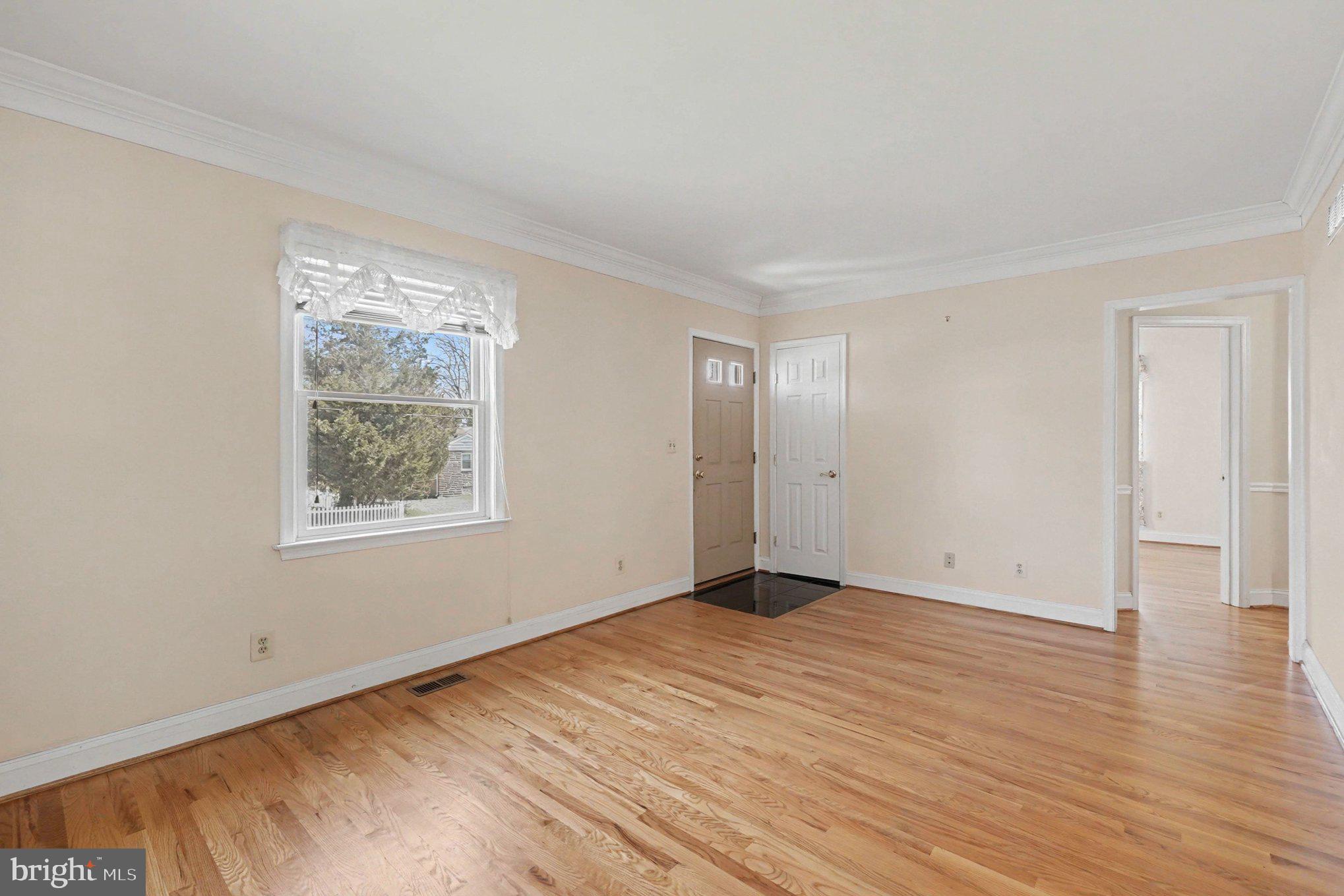 7908 Oakleigh Road Baltimore, MD 21234 - Photo 4 of 41 a view of an empty room with wooden floor and a window