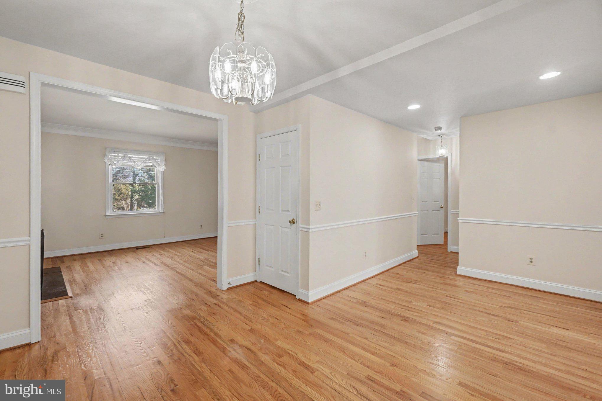 7908 Oakleigh Road Baltimore, MD 21234 - Photo 7 of 41 an empty room with wooden floor chandelier and windows