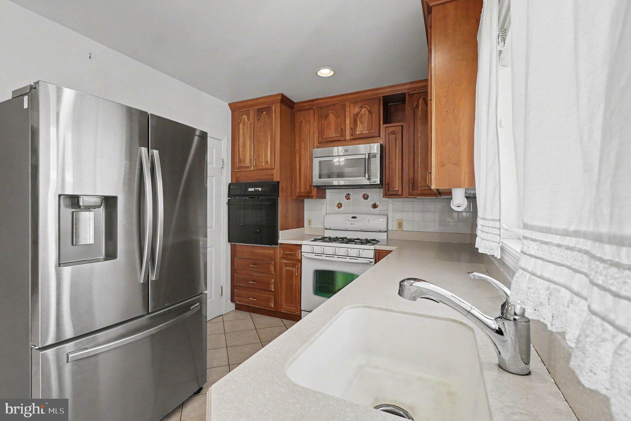 7908 Oakleigh Road Baltimore, MD 21234 - Photo 8 of 41 a kitchen with stainless steel appliances a refrigerator sink and microwave