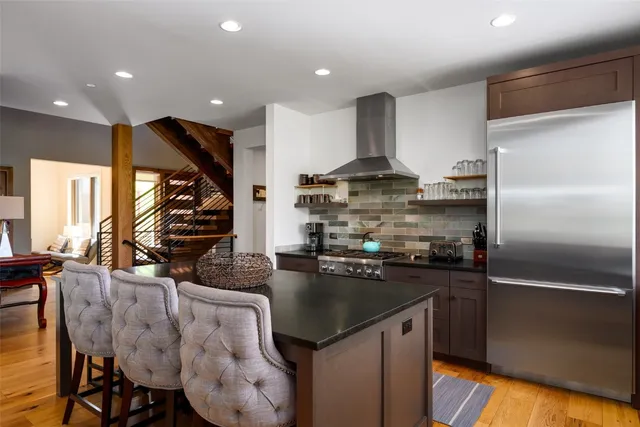 a kitchen with stainless steel appliances granite countertop a sink a stove and a refrigerator
