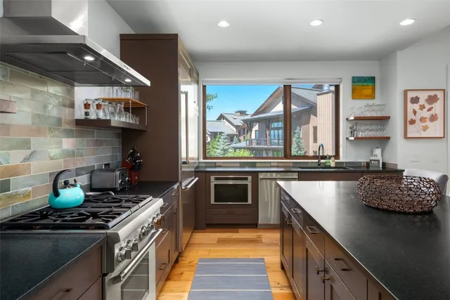 a kitchen with stainless steel appliances granite countertop a stove and a sink