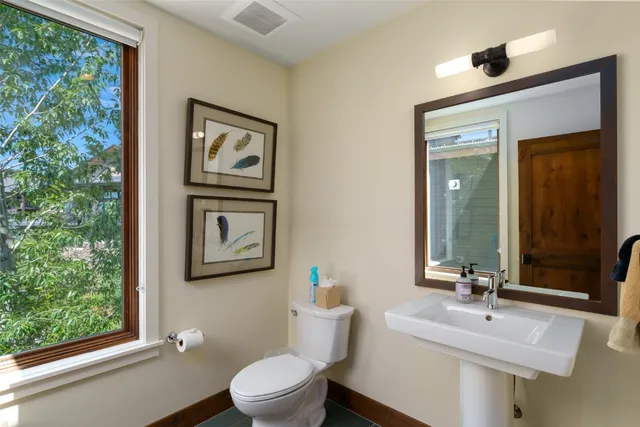 a bathroom with a toilet a sink and a large mirror