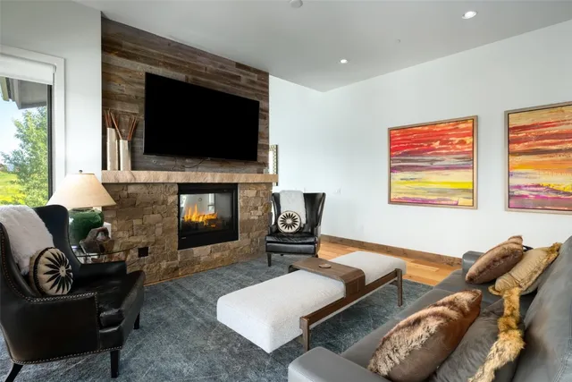a living room with furniture a flat screen tv and a fireplace