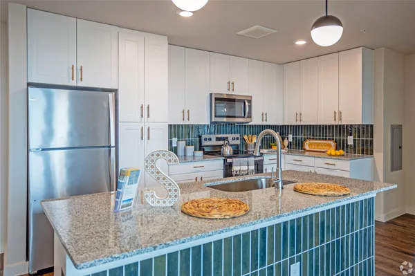 a kitchen with stainless steel appliances granite countertop a sink refrigerator and microwave