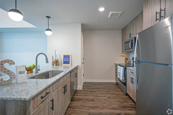 a kitchen with granite countertop a sink and a refrigerator