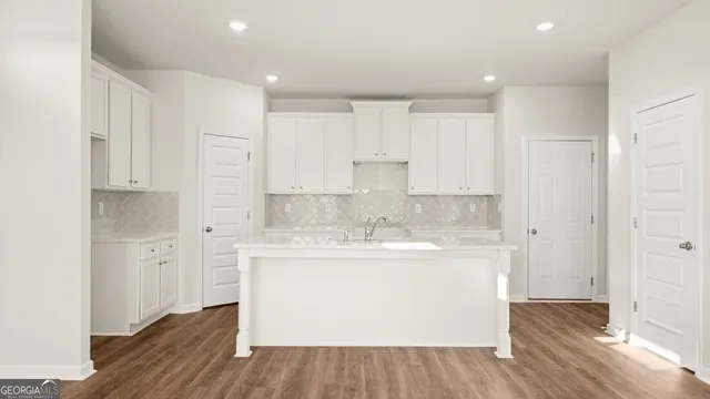 a kitchen with stainless steel appliances granite countertop a sink and cabinets with wooden floors