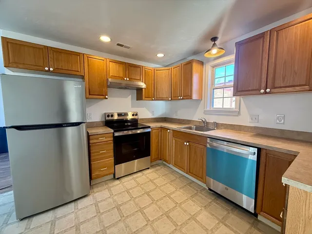 a kitchen with stainless steel appliances granite countertop a refrigerator sink and cabinets