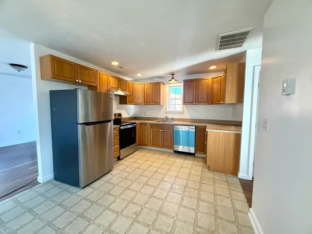 a kitchen with stainless steel appliances granite countertop a refrigerator and a stove top oven