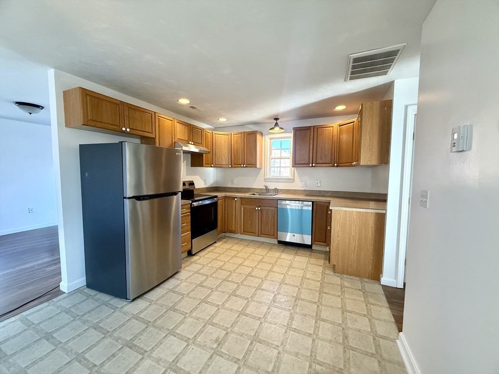 136 Eastford Road, Unit 2 Southbridge, MA 01550 - Photo 3 of 13 a kitchen with stainless steel appliances granite countertop a refrigerator and a stove top oven