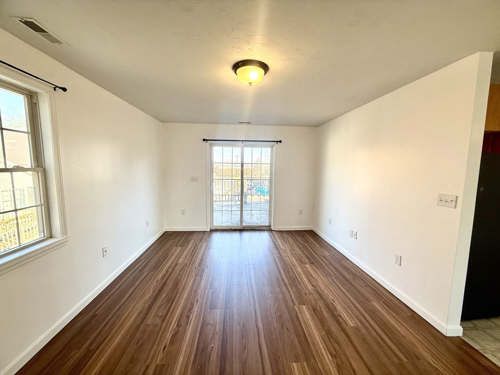 136 Eastford Road, Unit 2 Southbridge, MA 01550 - Photo 4 of 13 an empty room with wooden floor and windows