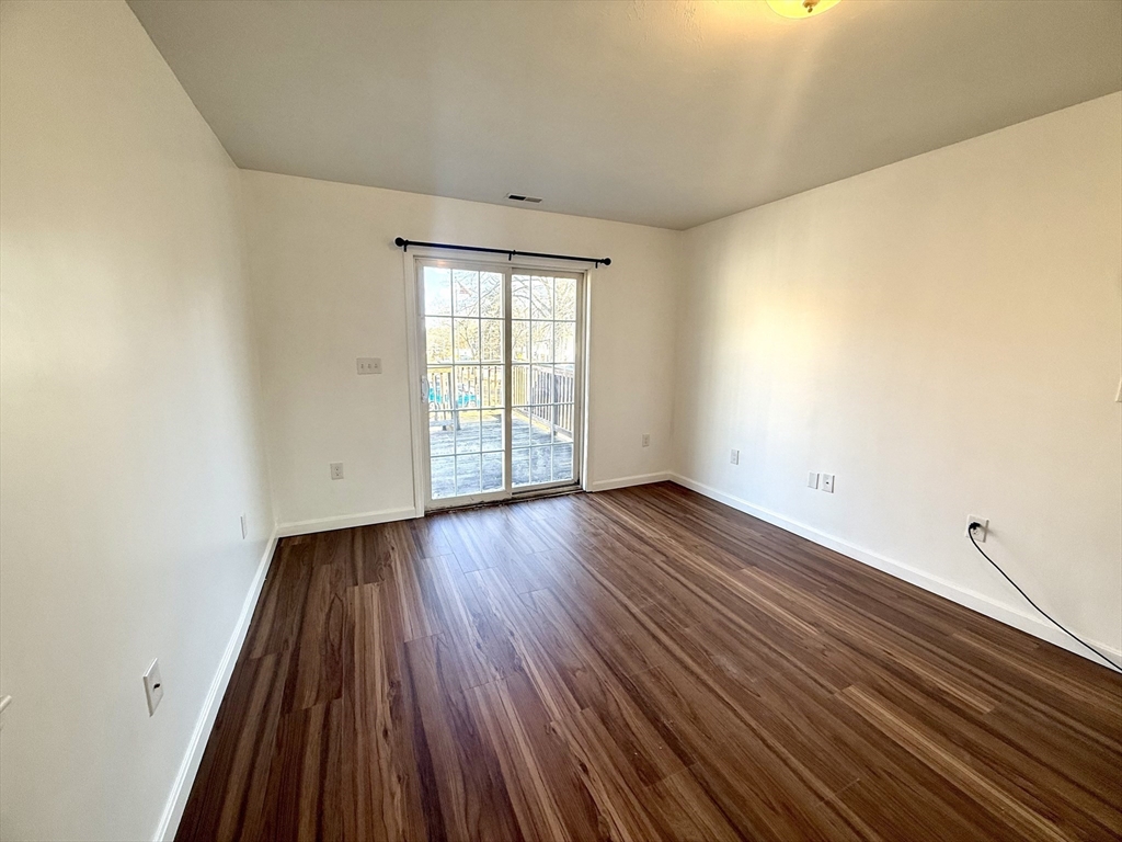 136 Eastford Road, Unit 2 Southbridge, MA 01550 - Photo 5 of 13 a view of an empty room with wooden floor and a window