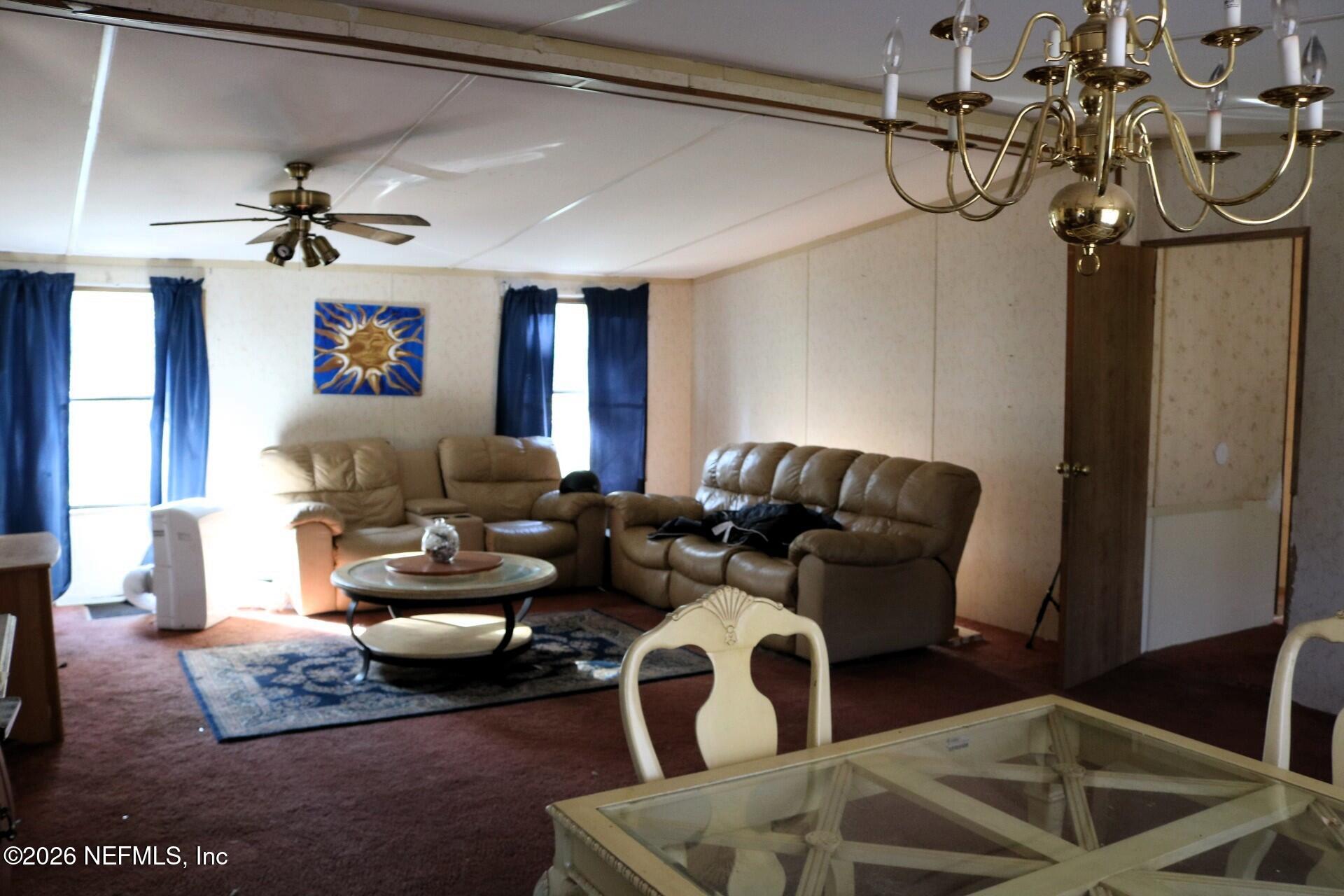 54089 Huckleberry Lane Callahan, FL 32011 - Photo 14 of 18 a living room with furniture a chandelier and a window