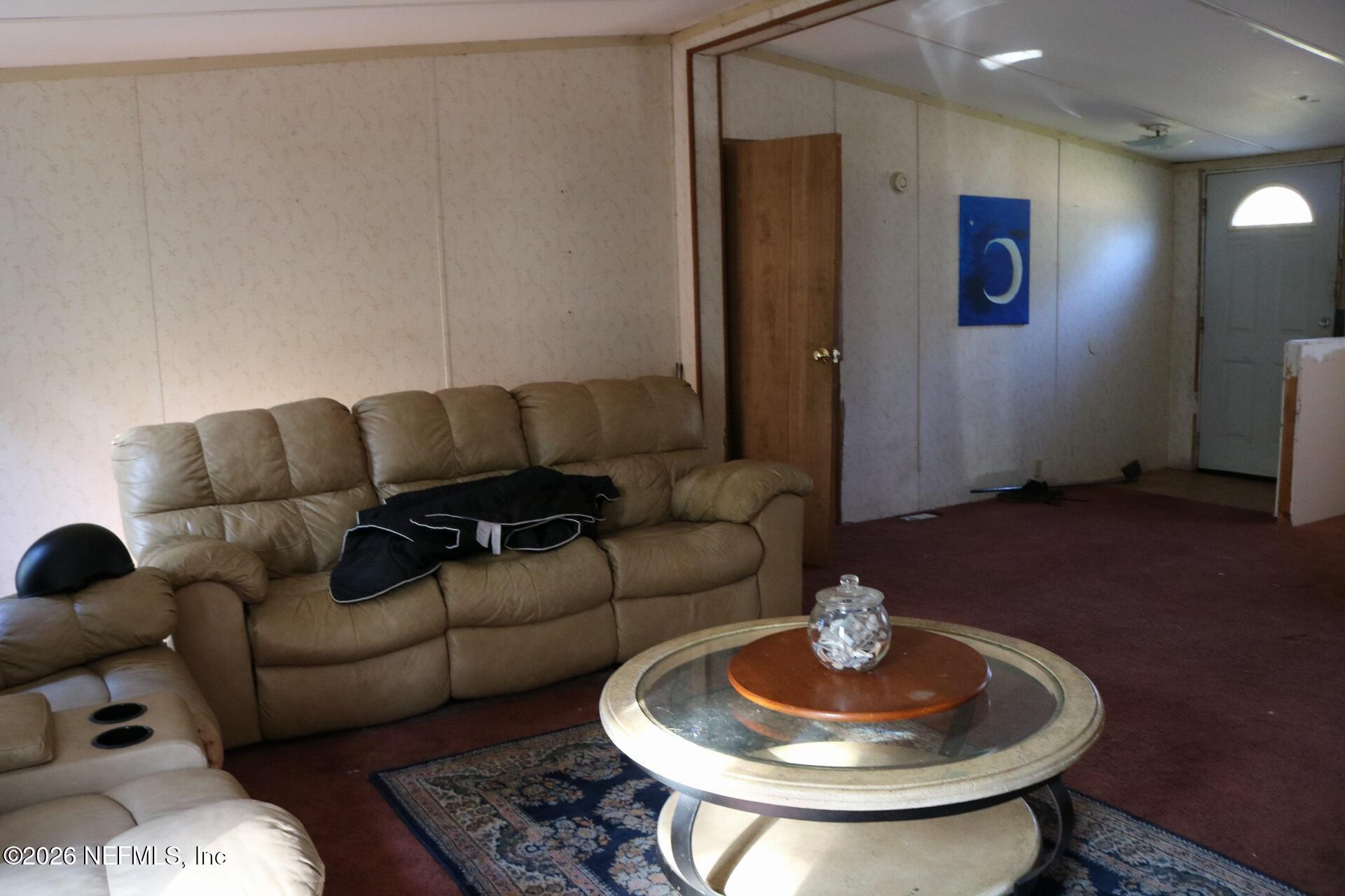 54089 Huckleberry Lane Callahan, FL 32011 - Photo 18 of 18 a living room with furniture a chandelier and a dining table