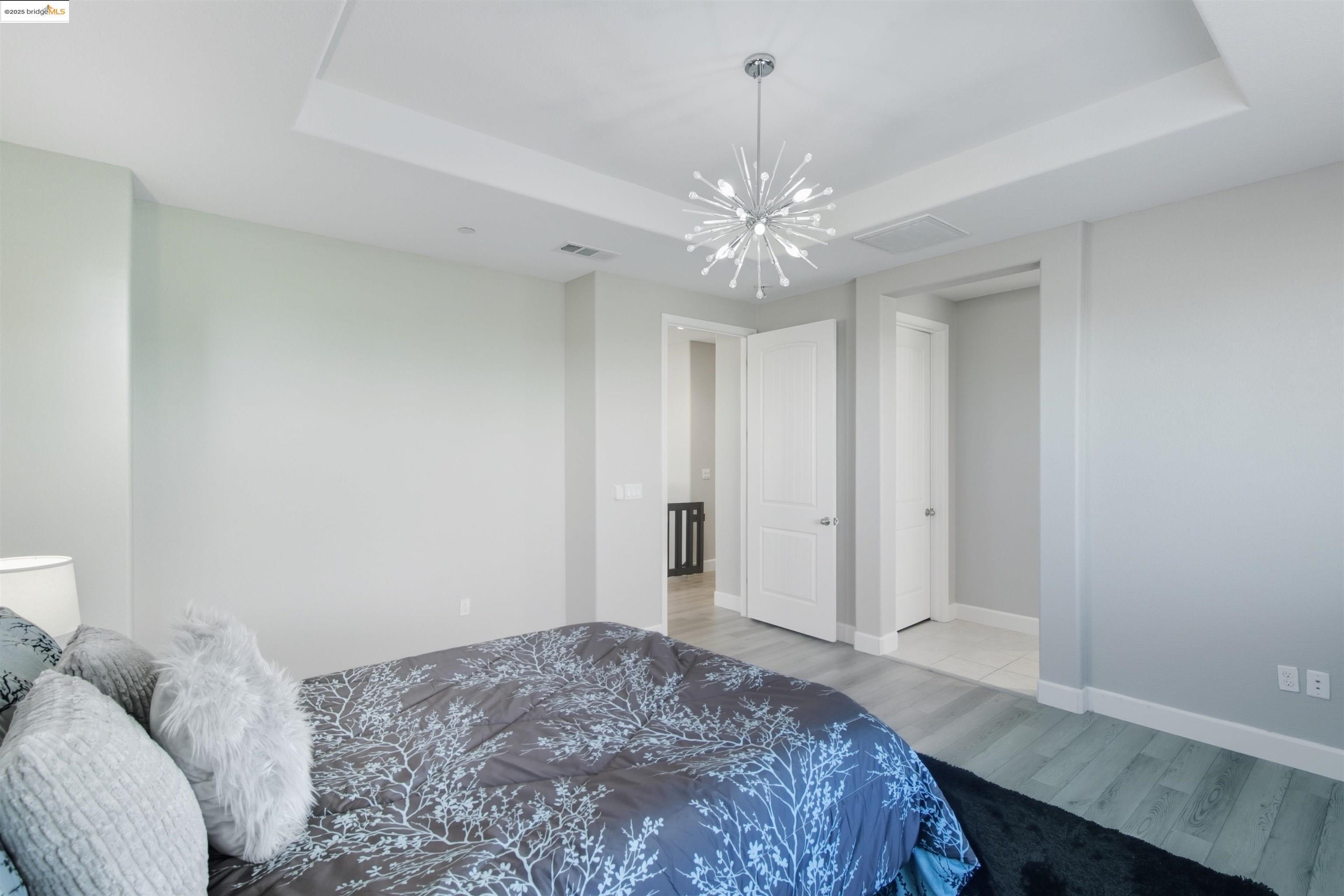 536 Aster Street Vacaville, CA 95688 - Photo 29 of 53 Bedroom featuring a tray ceiling, light wood-style floors, and a chandelier