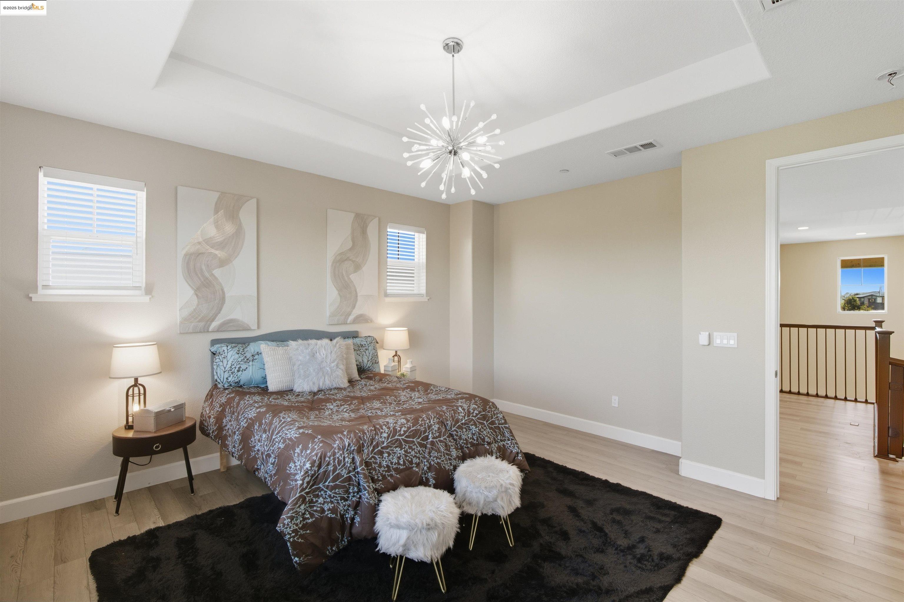 536 Aster Street Vacaville, CA 95688 - Photo 30 of 53 Bedroom with a raised ceiling, light wood-style flooring, and a chandelier