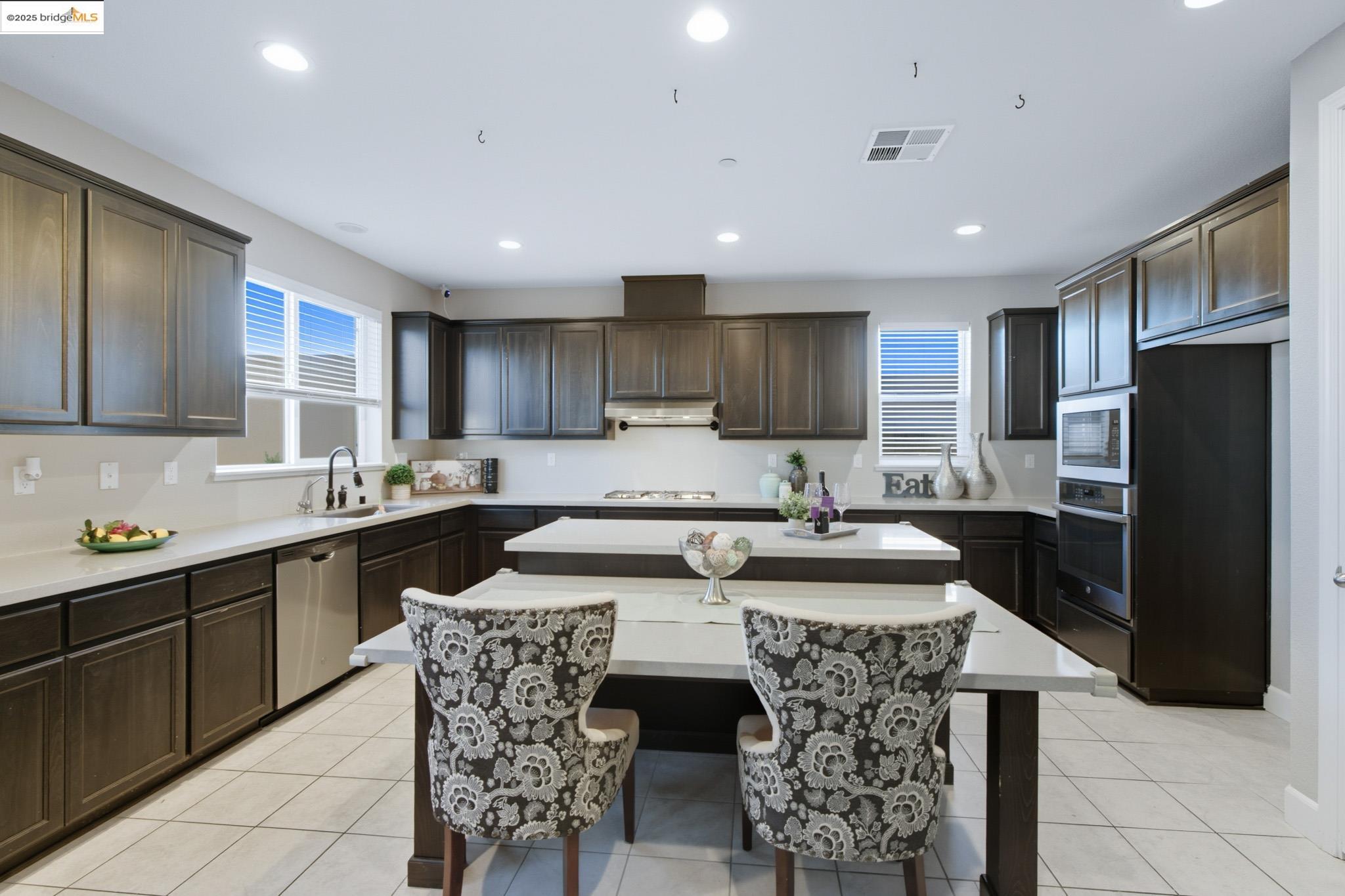 536 Aster Street Vacaville, CA 95688 - Photo 45 of 53 Kitchen with a center island, light tile patterned flooring, dark brown cabinetry, recessed lighting, and stainless steel appliances