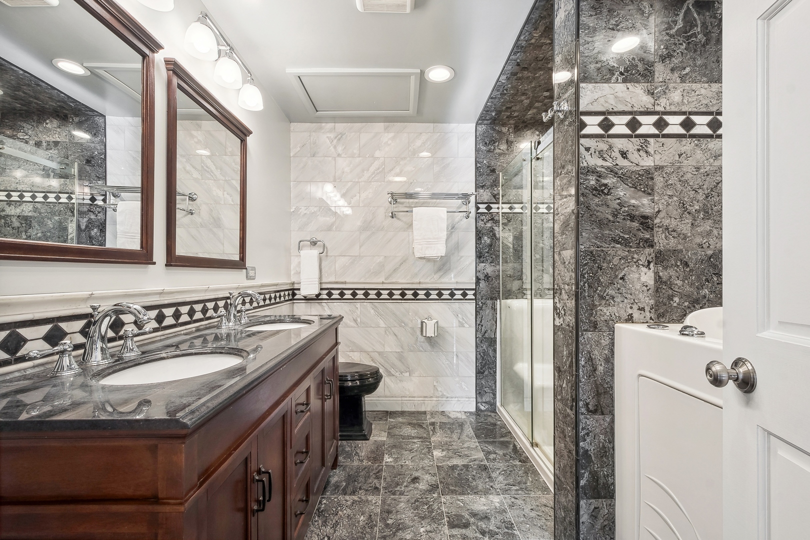 207 North Happ Road Northfield, IL 60093 - Photo 15 of 28 a bathroom with a sink a mirror and a shower