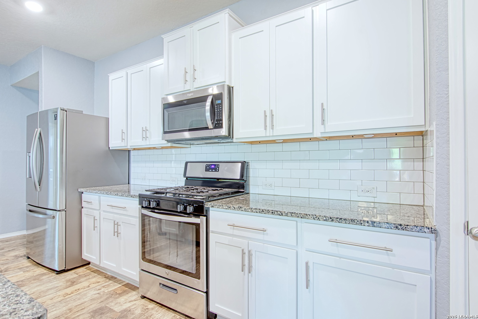 29516 Winter Copper Bulverde, TX 78163 - Photo 11 of 42 a kitchen with granite countertop white cabinets and stainless steel appliances