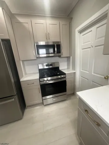 a kitchen with granite countertop white cabinets and black appliances
