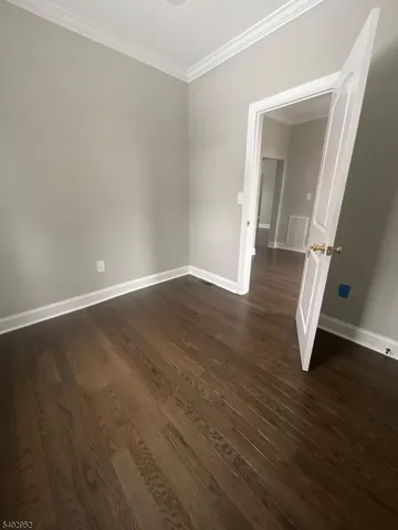 an empty room with wooden floor and staircase