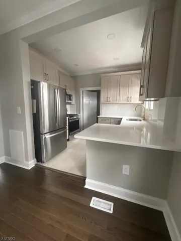 a kitchen with stainless steel appliances granite countertop a refrigerator and a sink