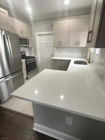 a kitchen with stainless steel appliances a refrigerator a sink a stove a microwave and cabinets