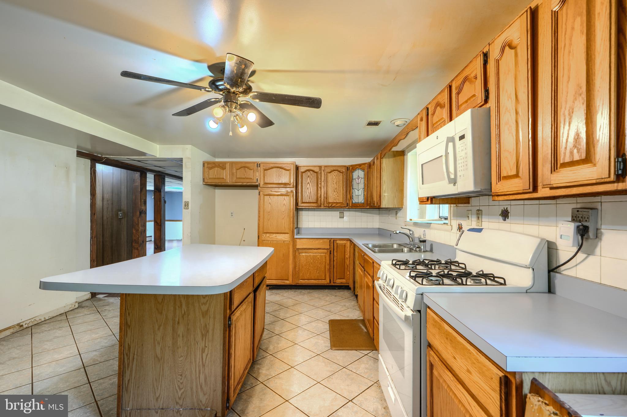 3743 Schroeder Avenue Perry Hall, MD 21128 - Photo 40 of 60 a kitchen with stainless steel appliances granite countertop a sink a stove and a wooden floors