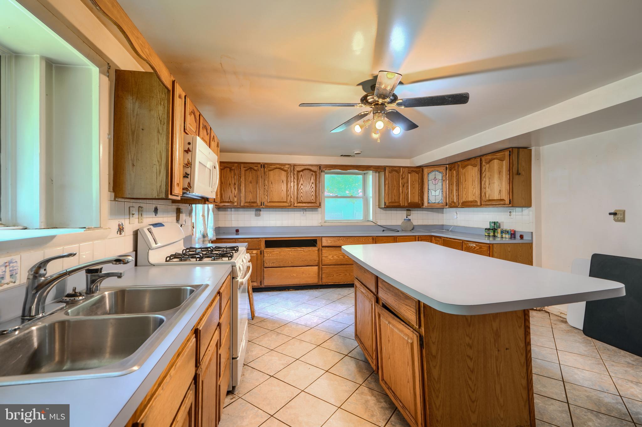 3743 Schroeder Avenue Perry Hall, MD 21128 - Photo 41 of 60 a kitchen with a sink a counter top space cabinets and stainless steel appliances
