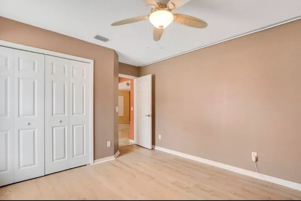 an empty room with a chandelier fan
