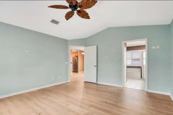a view of an empty room and window with wooden floor