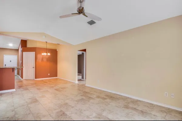 en empty room with a ceiling fan and a window