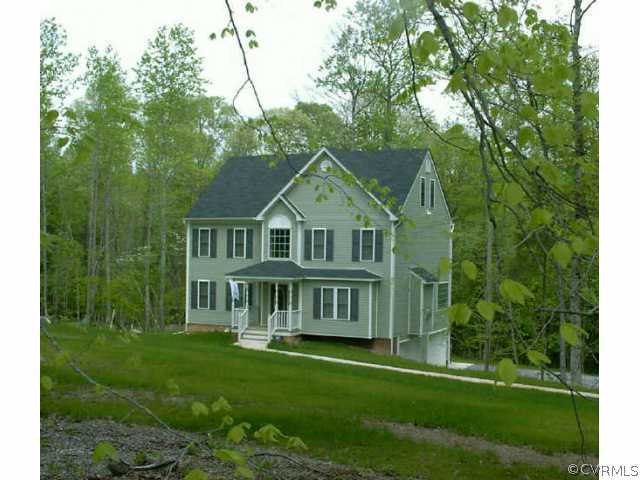 a view of a house with a big yard and large trees