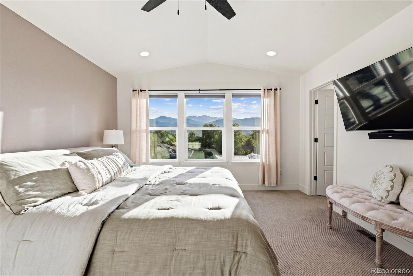 7875 West 43rd Circle Wheat Ridge, CO 80033 - Photo 29 of 50 a spacious bedroom with a bed and a flat screen tv