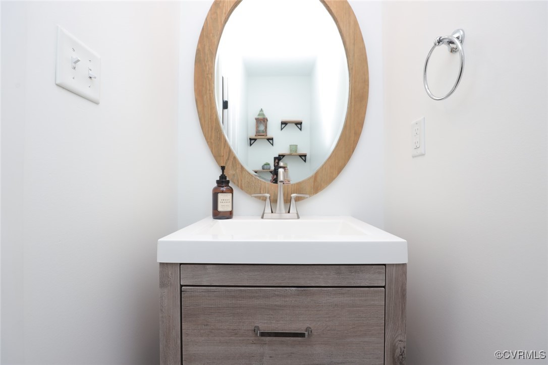 1113 Bradbury Road Moseley, VA 23120 - Photo 22 of 43 a bathroom with a sink a mirror and a light fixture