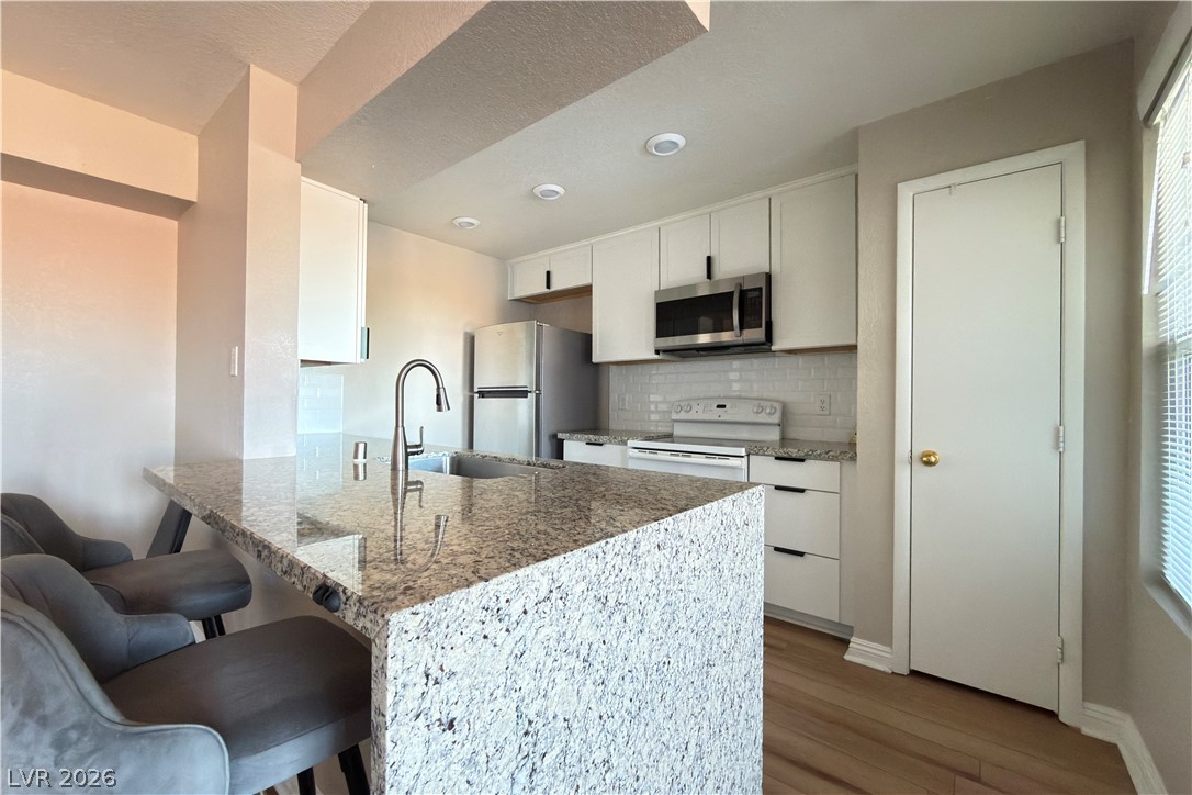 8101 West Flamingo Road, Unit 2131 Las Vegas, NV 89147 - Photo 2 of 13 Culinary delights await in this bright kitchen with an inviting island and essential appliances.