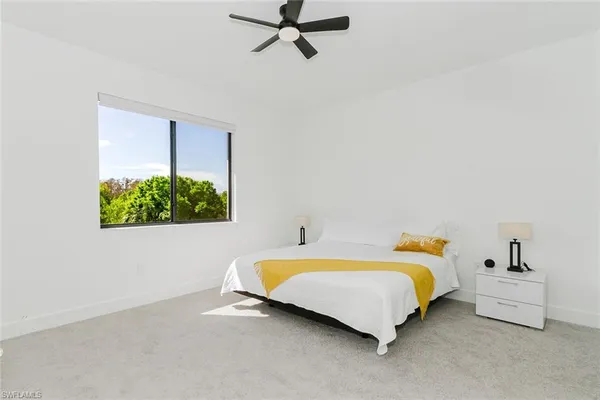 a spacious bedroom with a bed and a window